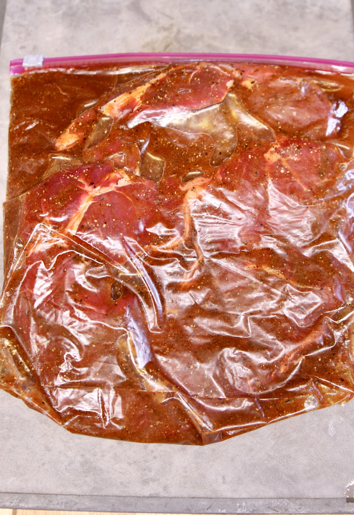 Marinating steak in a zip top bag with fajita marinade.