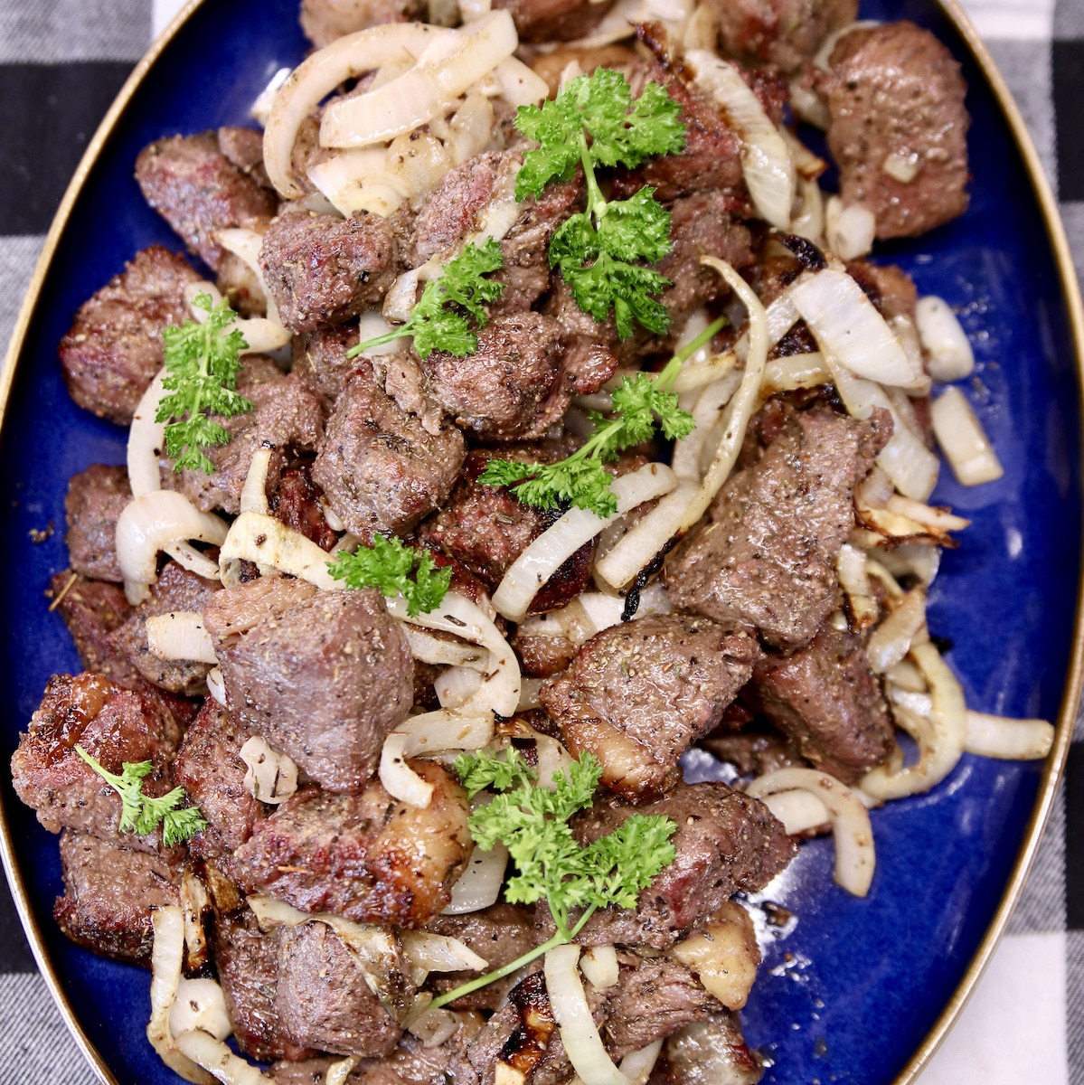 Steak bites with onions on a platter.