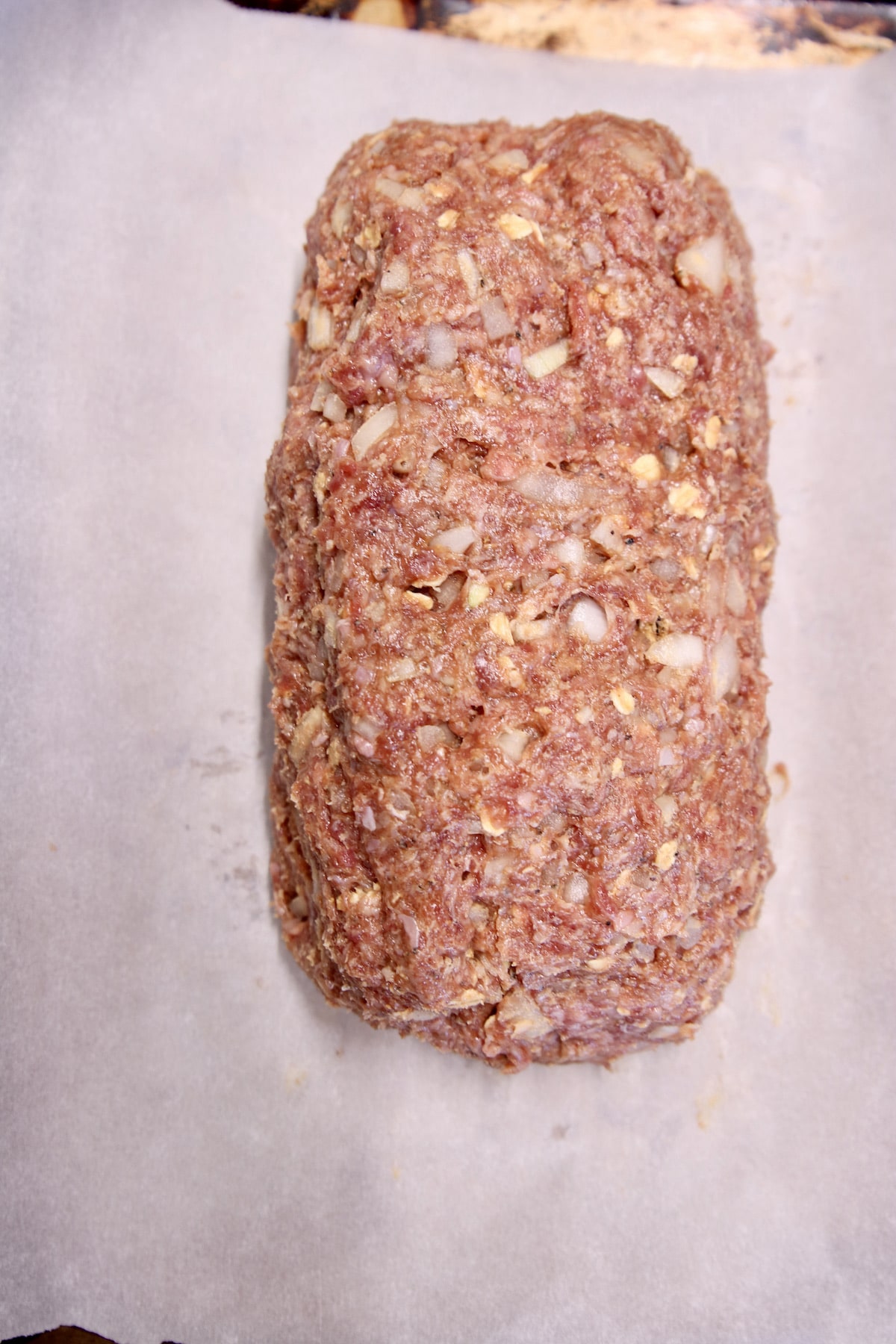 raw meatloaf on parchment paper.