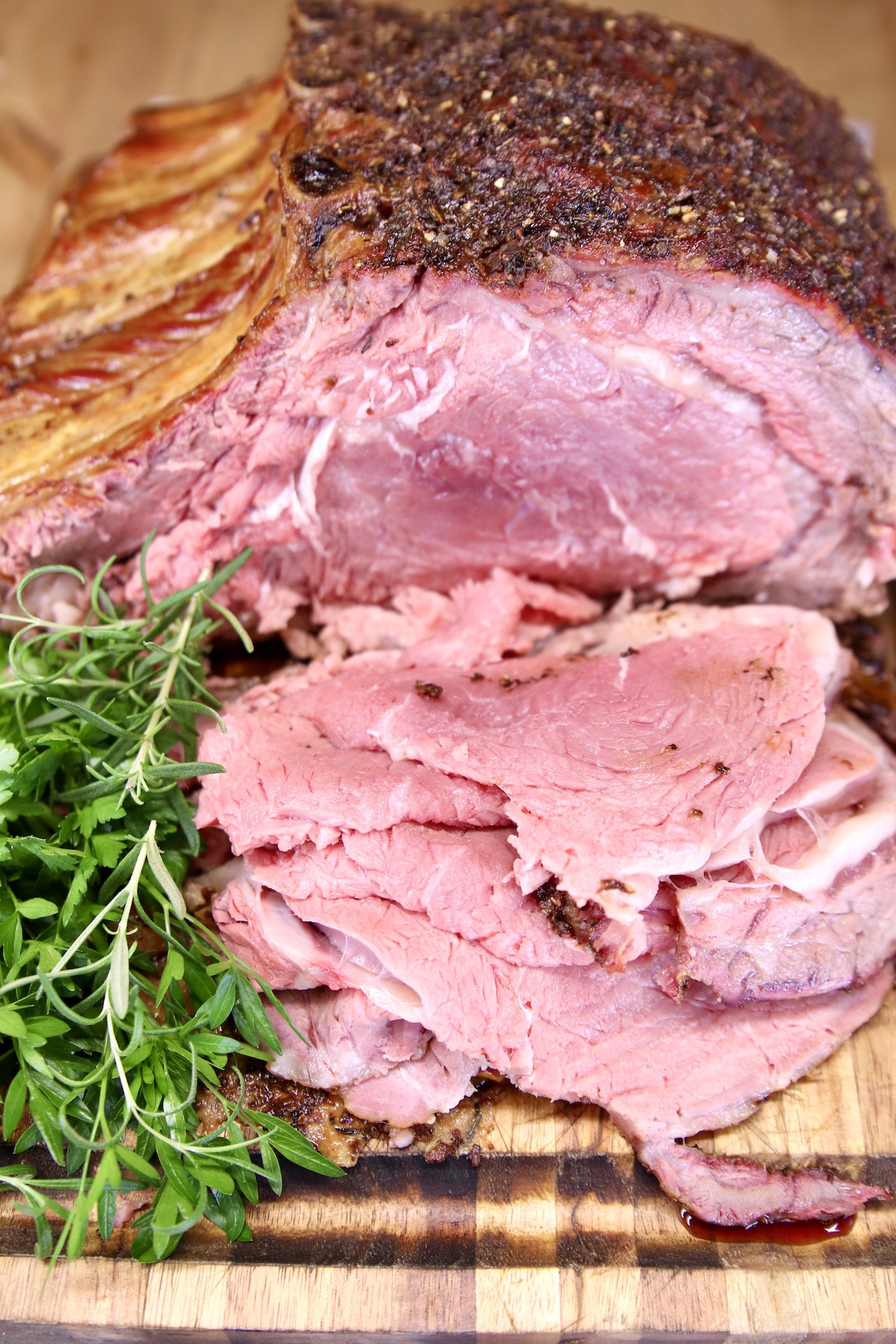 Sliced prime rib roast - bone-in, on cutting board.