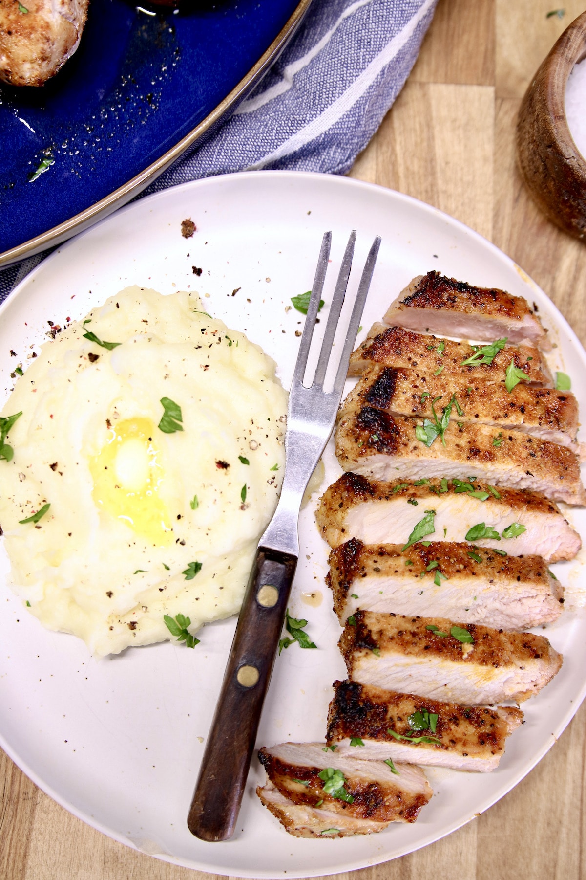 Sliced pork chop on a plate with mashed potatoes.