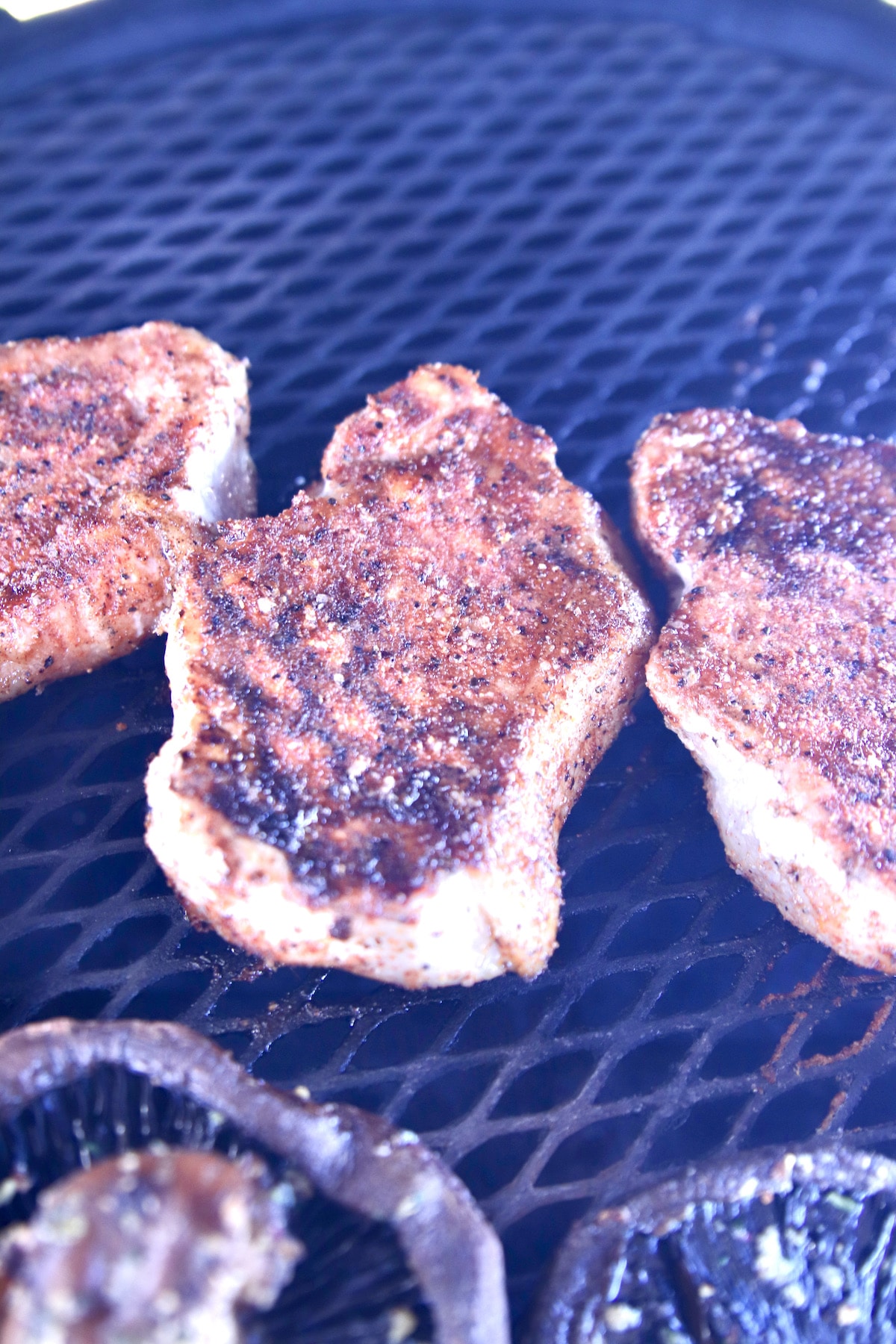 Pork chops on a grill.