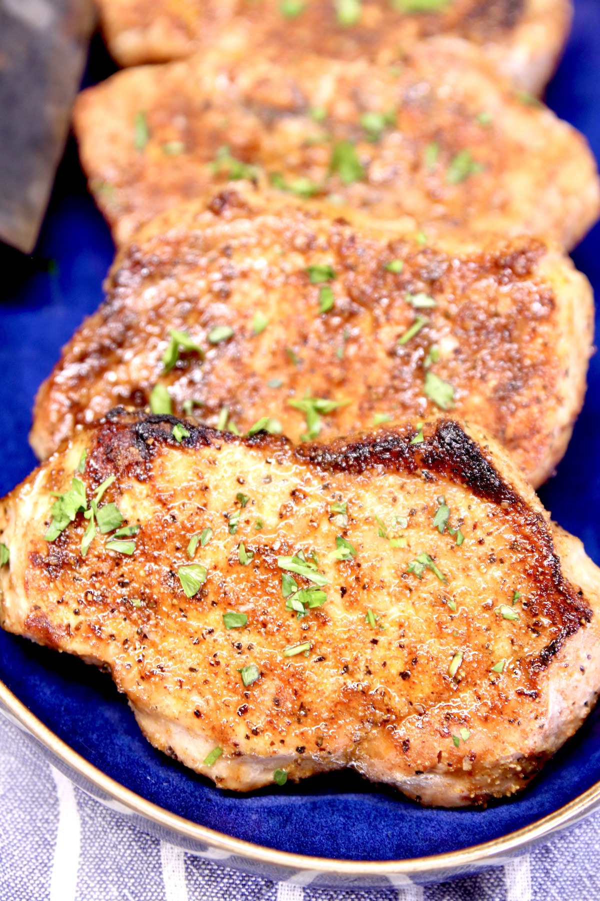 Grilled pork chops on a blue platter.