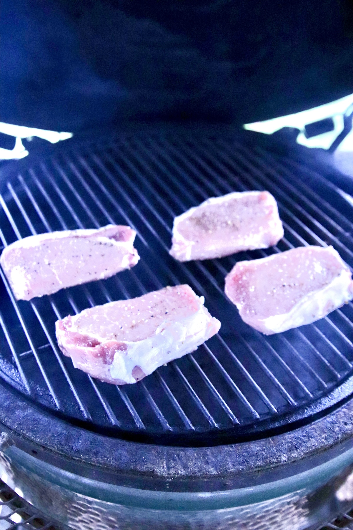 4 pork chops on a grill.