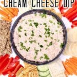 Bowl of salmon dip on a tray with crackers and vegetables.