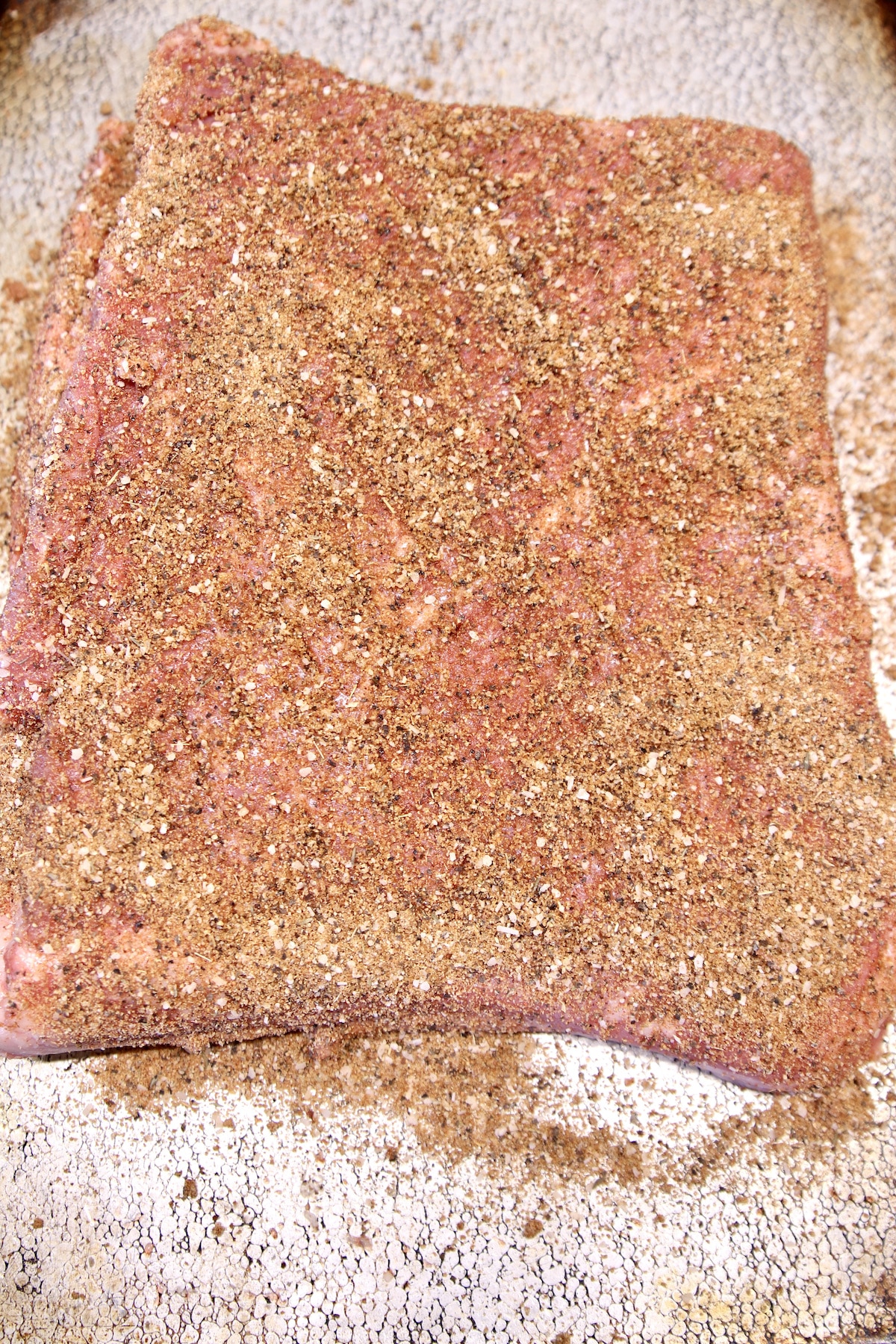 Brisket flat sprinkled with dry rub.