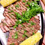 Platter of sliced pork and corn on the cob. Text overlay.