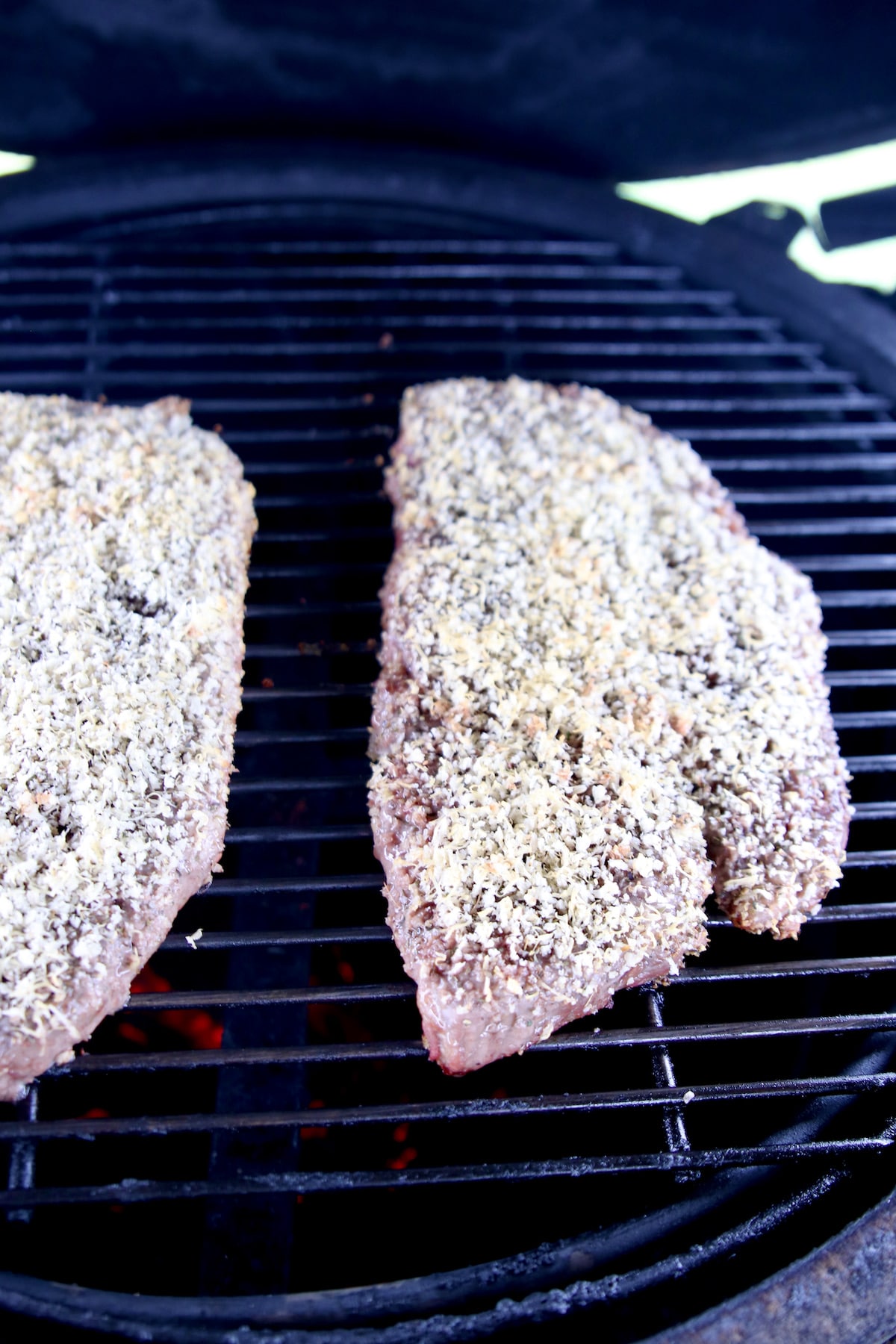 Parmesan crusted sirloins on grill.