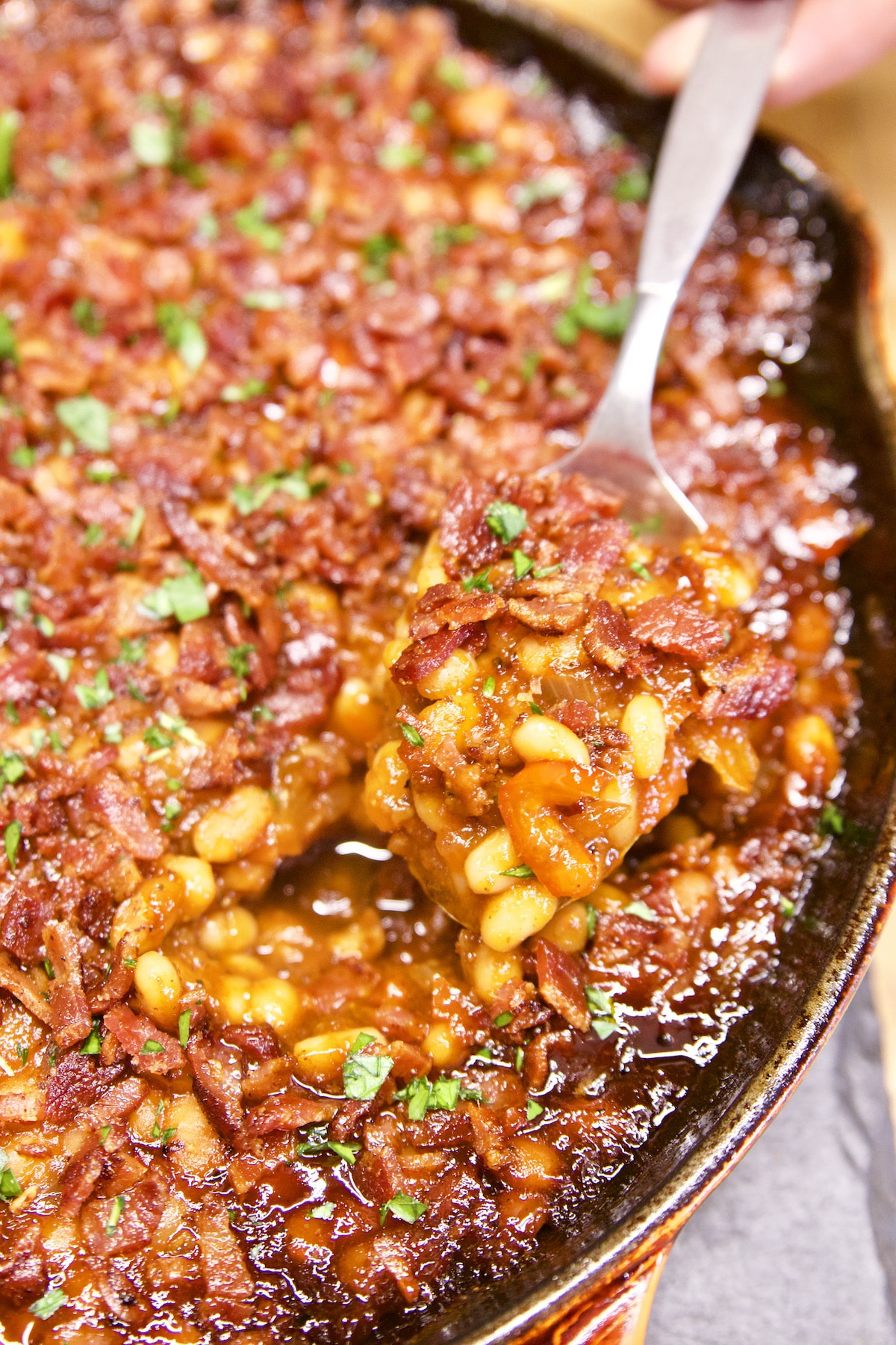 Skillet of baked beans with spoon.