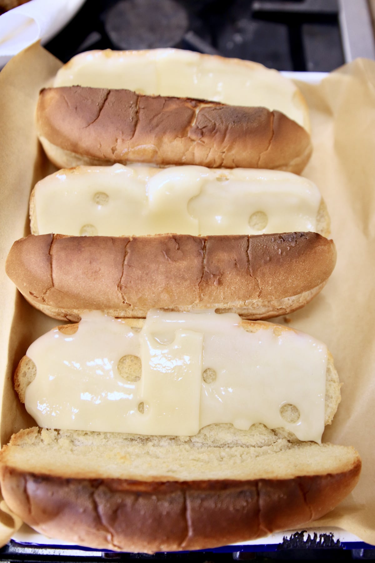 Melting Swiss cheese slices onto hoagie buns