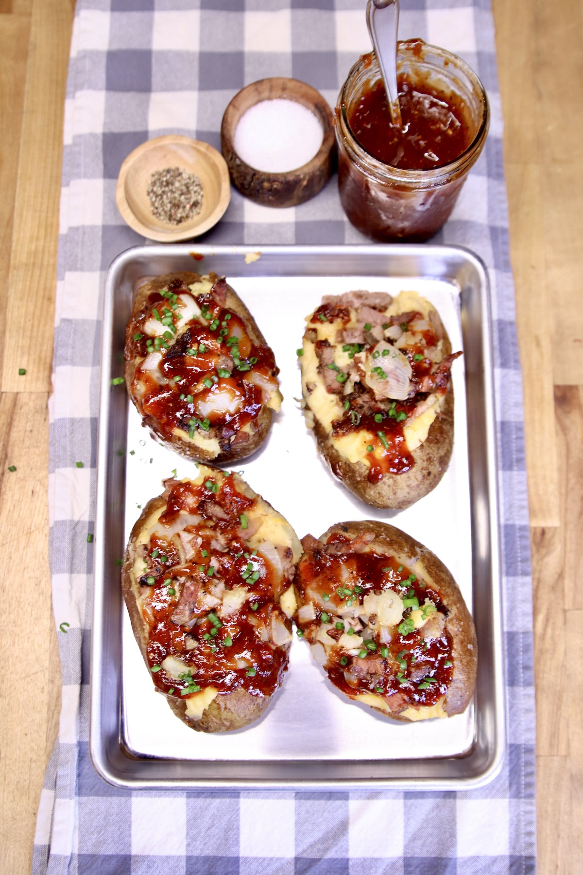Twice baked potatoes with bbq brisket on a sheet pan.
