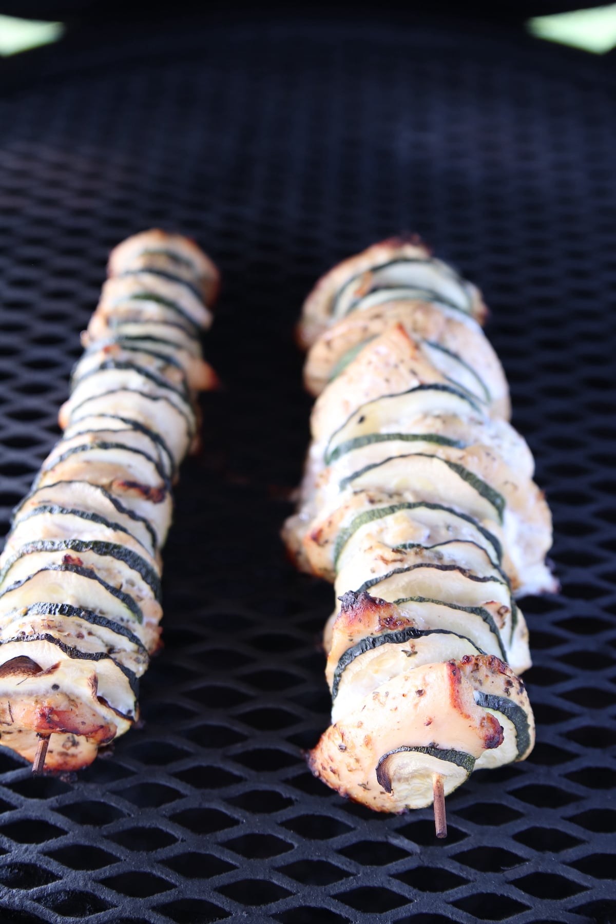 Chicken skewers with zucchini on a grill.