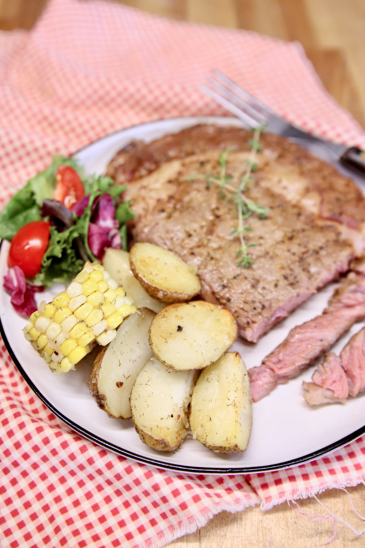Steak, potatoes and corn on a plate.