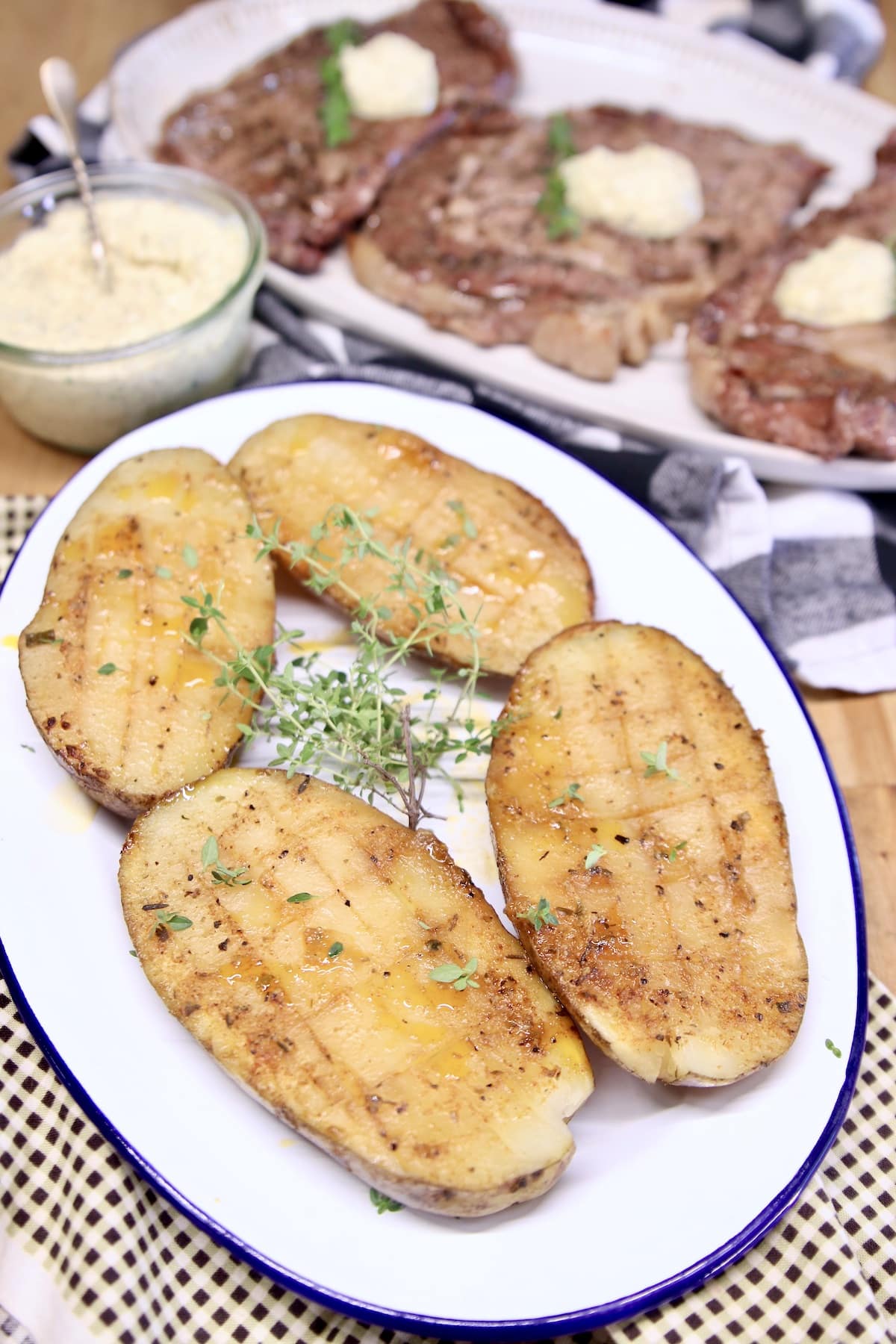 Grilled baked potatoes halves on a platter.