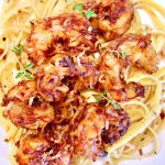 Grilled coconut shrimp over pasta - text overlay.