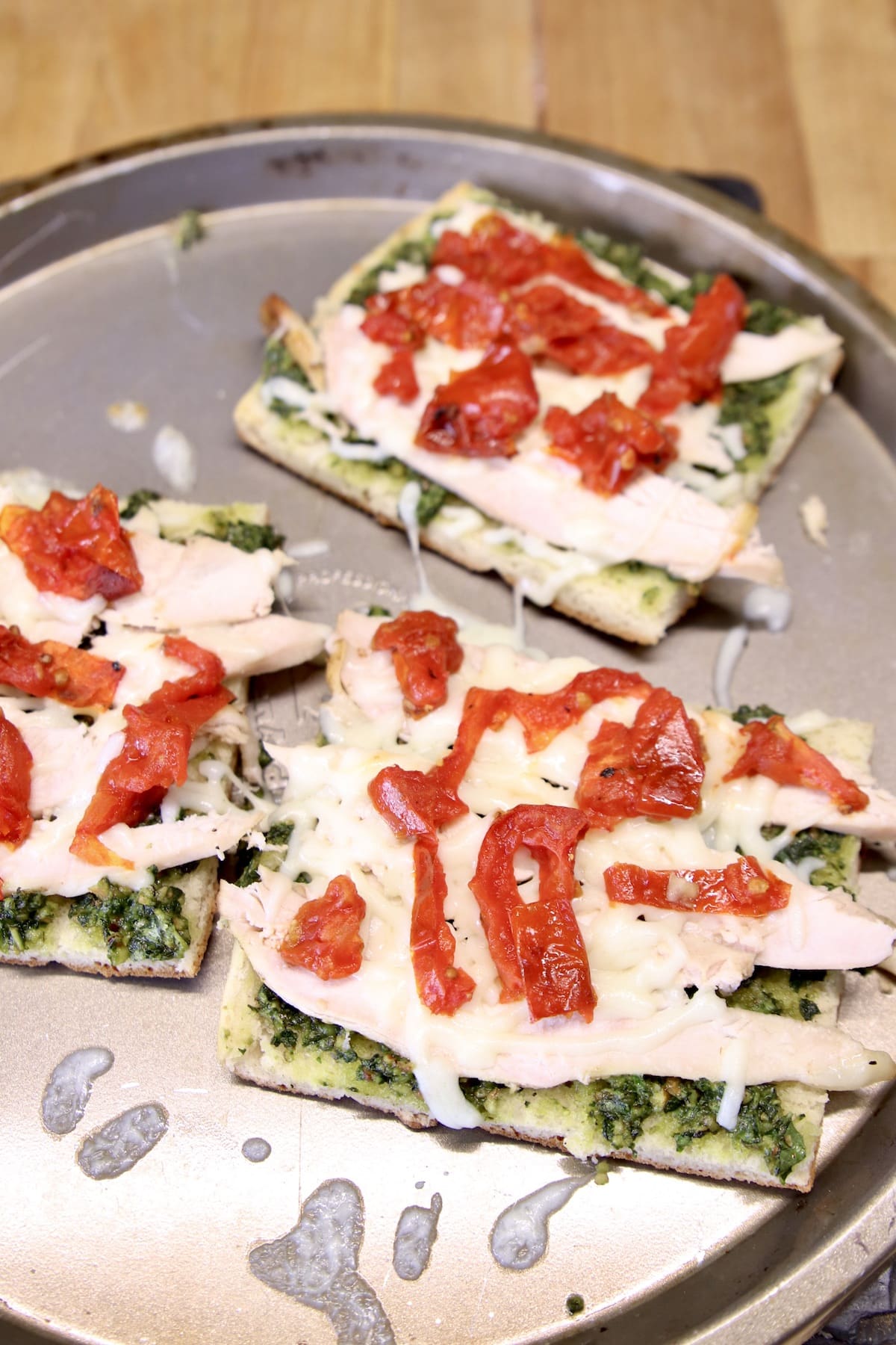 open faced pesto chicken sandwich with tomatoes.