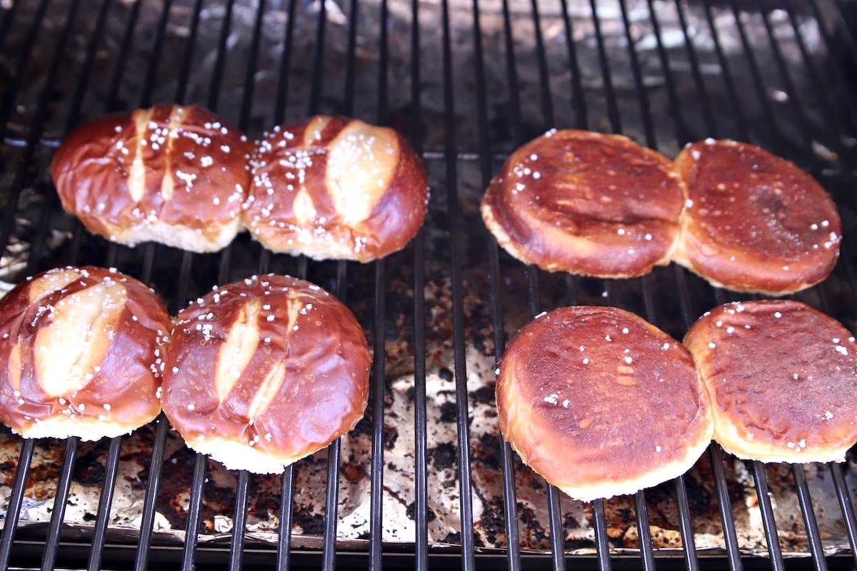 toasting pretzel buns on a grill.