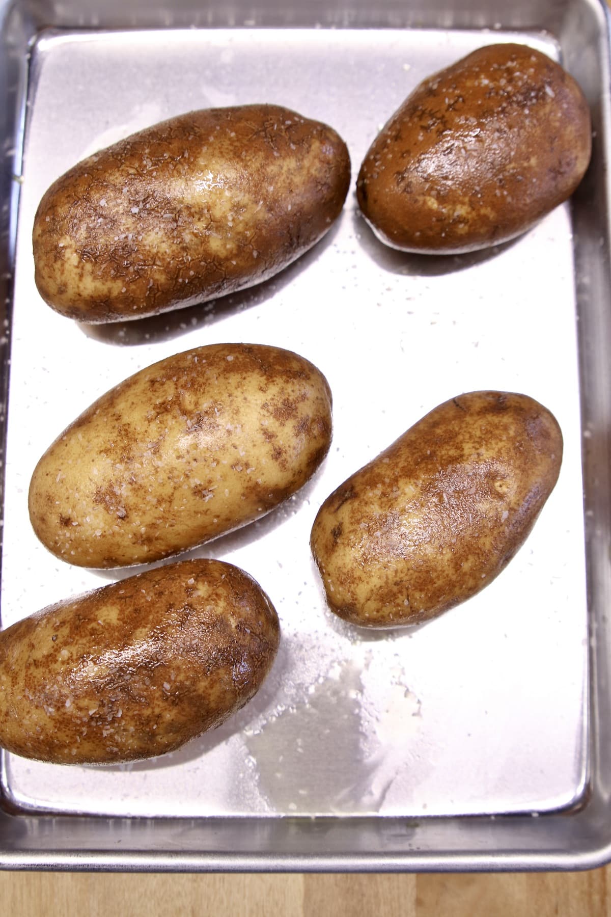 5 Baked Potatoes on a baking sheet