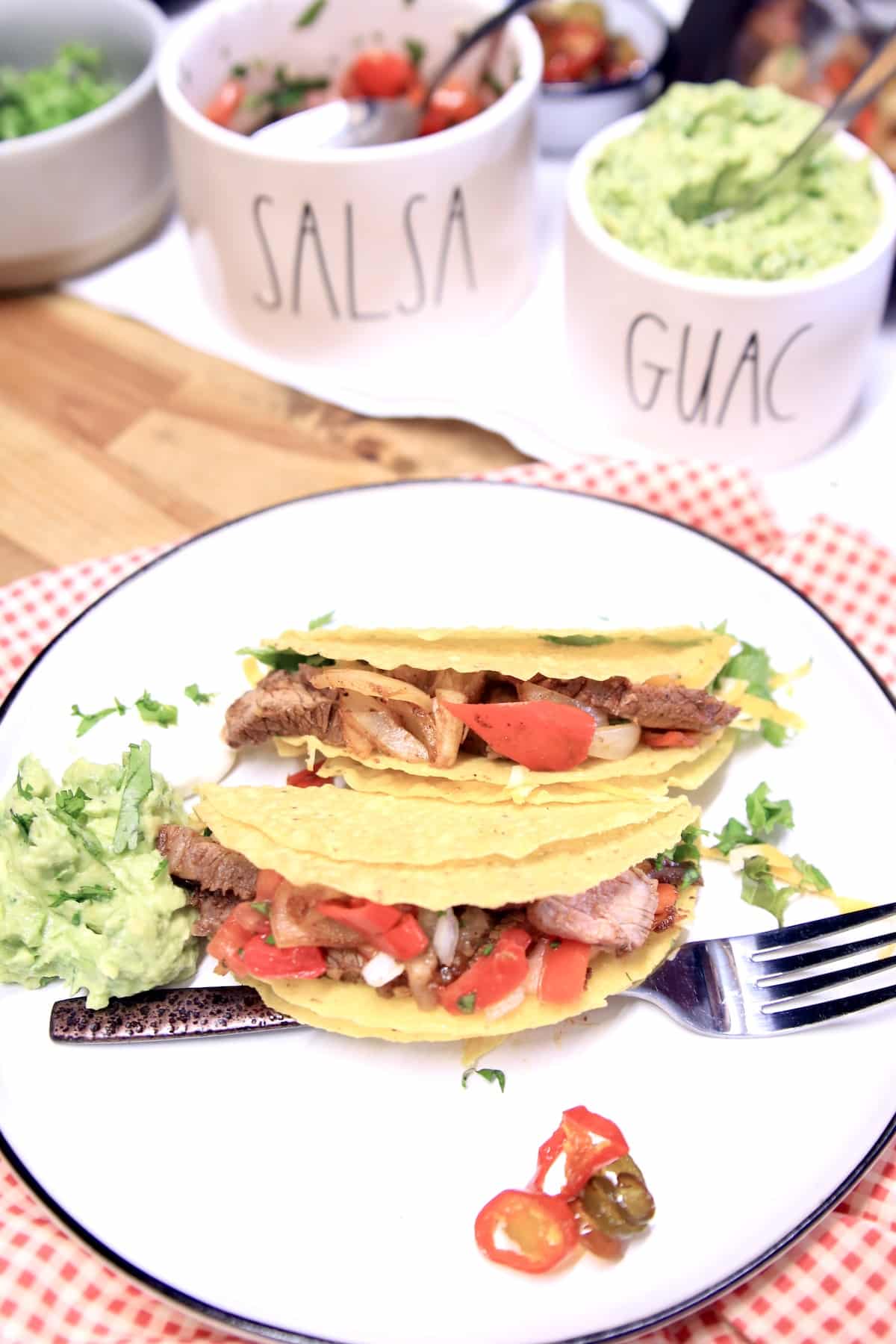 Plate of 2 steak tacos with guacamole.
