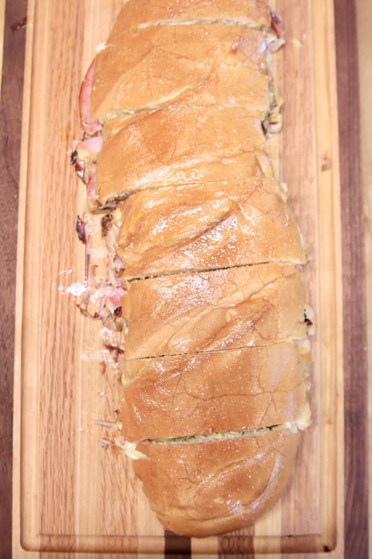 Italian loaf sandwich, sliced on a cutting board.