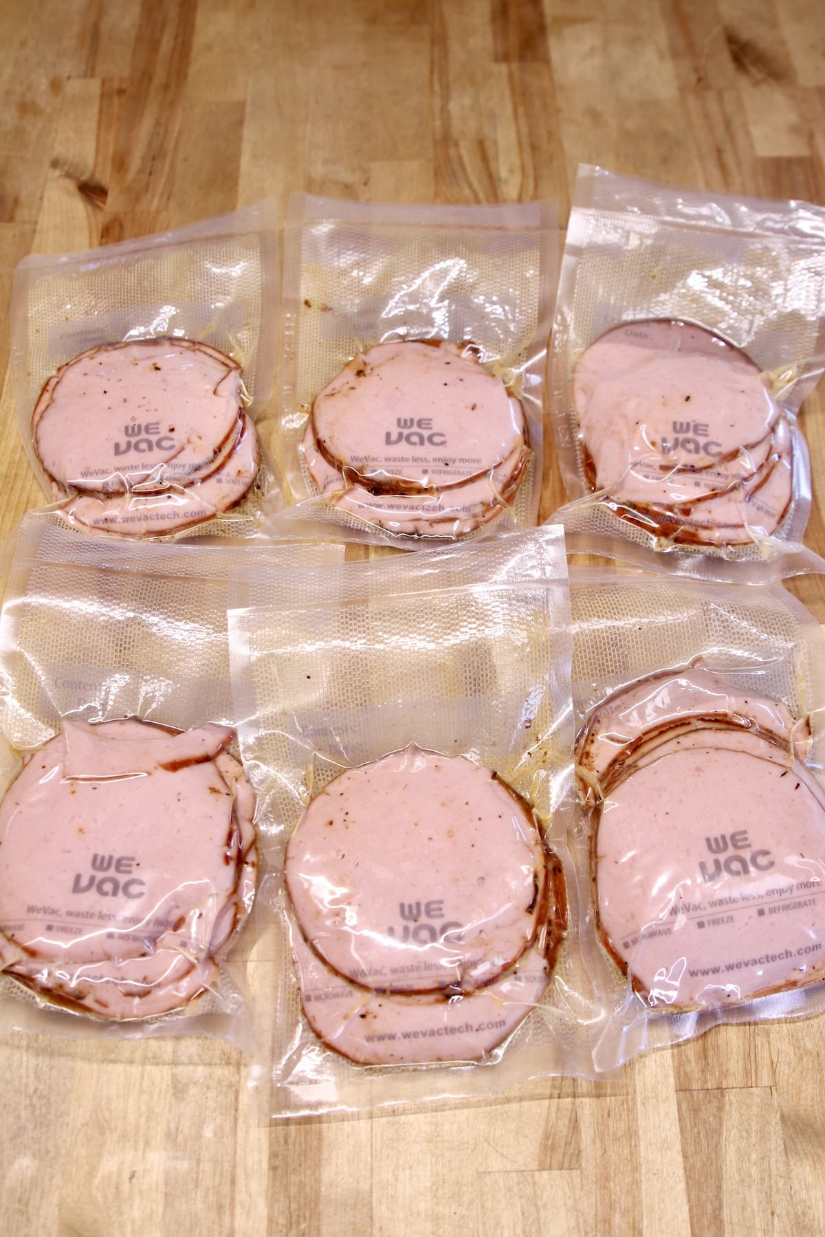 Vacuum sealed packages of sliced bologna.