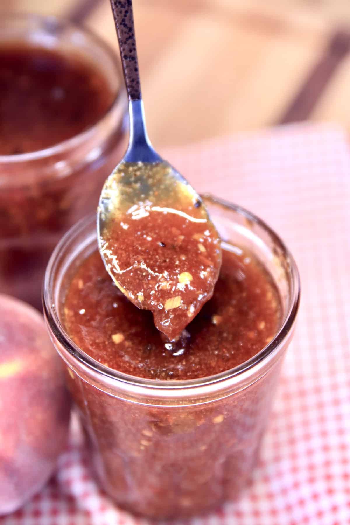 Spoonful of bbq sauce dipping from jar.