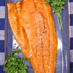 Grilled salmon fillet on blue platter. Text overlay.
