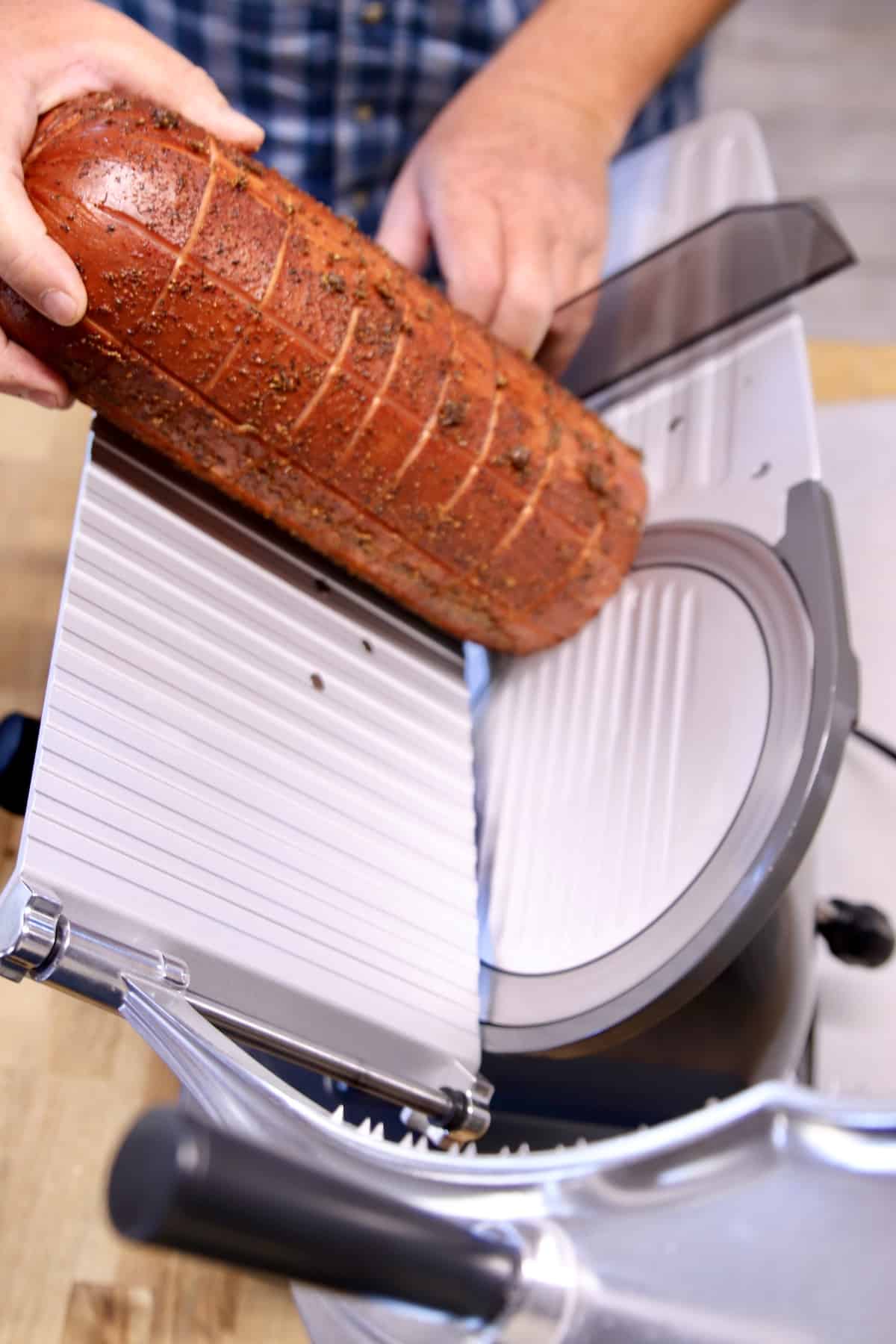 Slicing bologna with a meat slicer.