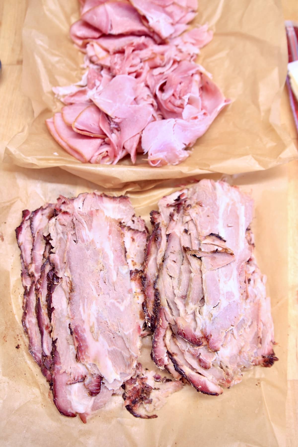sliced ham and pork shoulder on parchment paper.