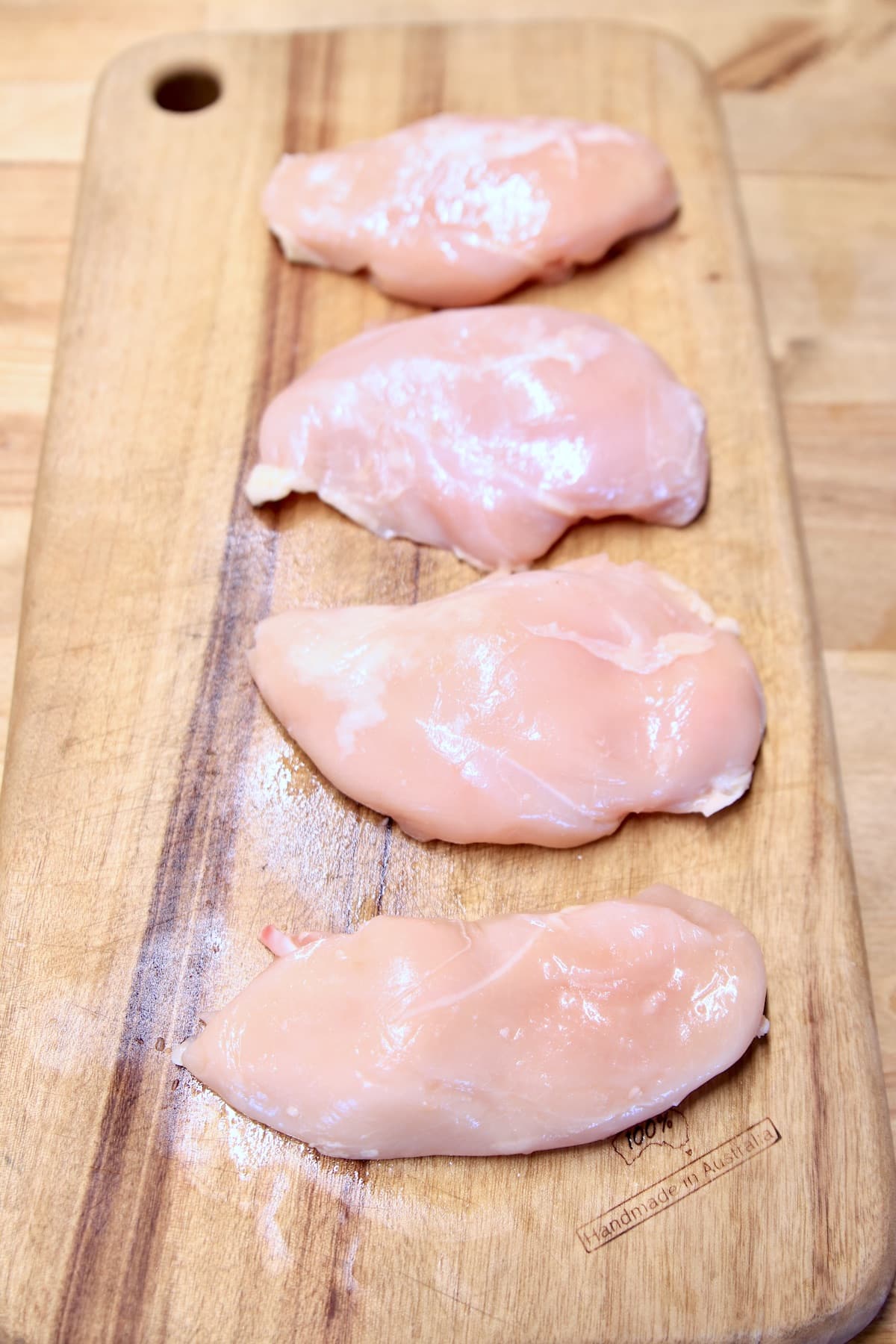 Chicken breasts on a cutting board.