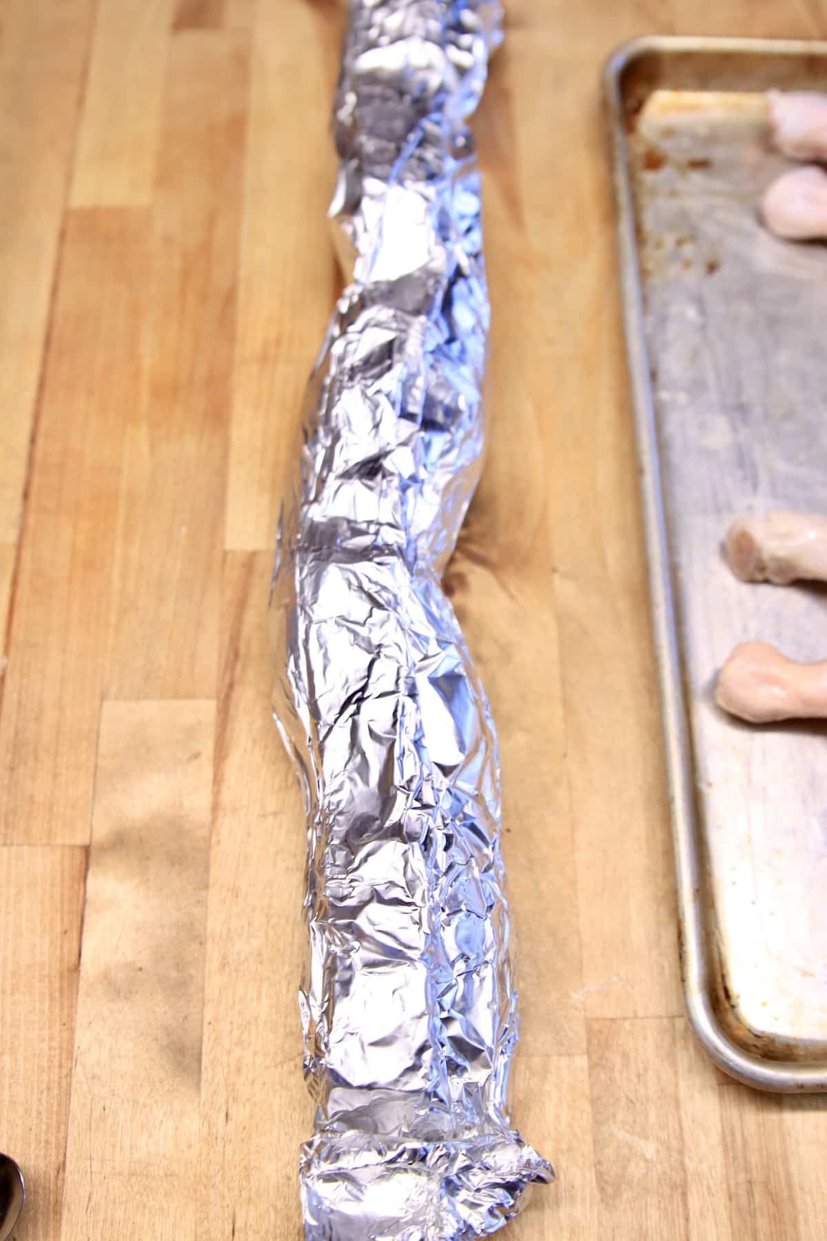Long foil packet with potatoes inside.