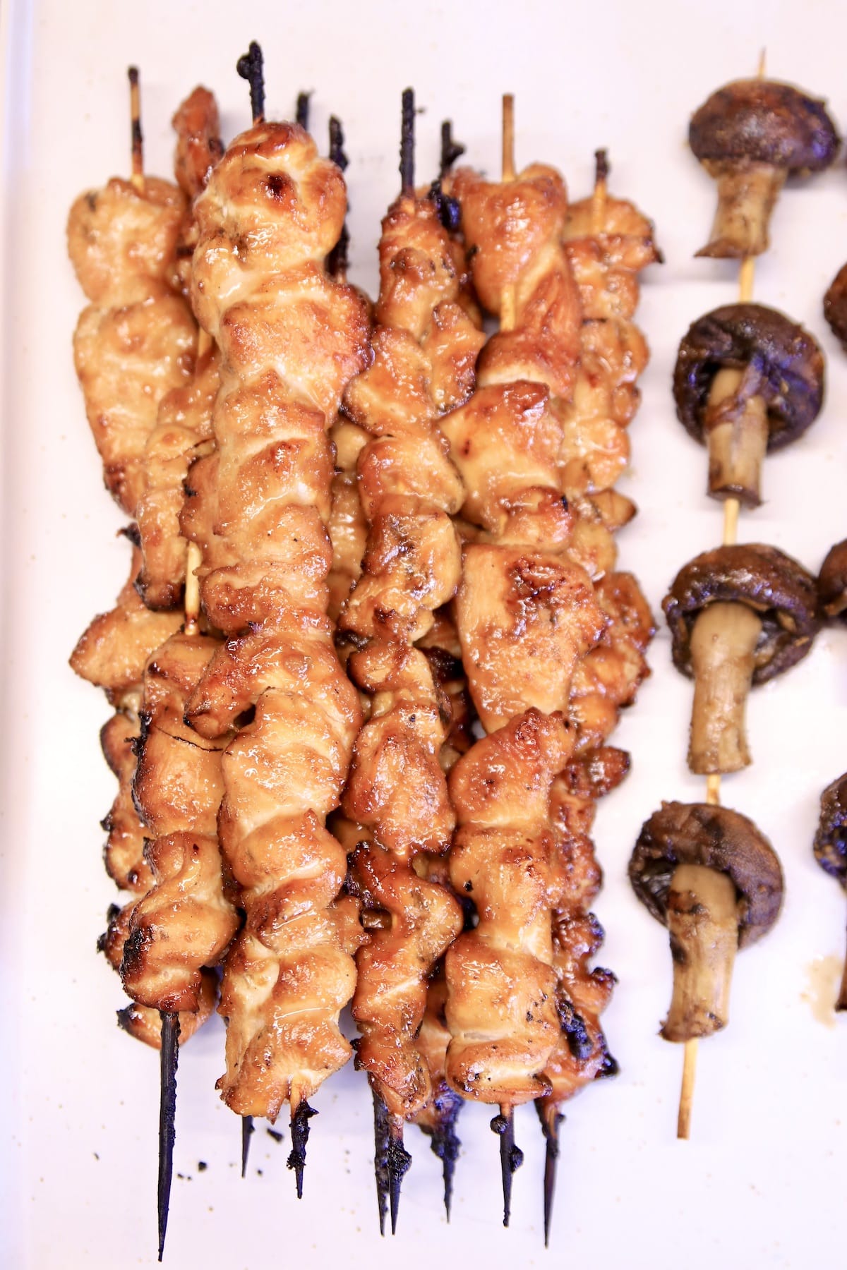 Chicken skewers with mushrooms on a platter.