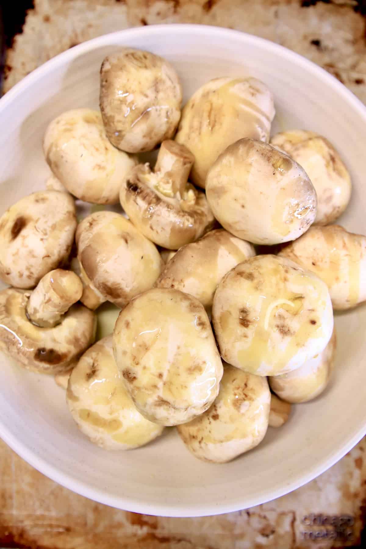 Whole white mushrooms in a bowl.