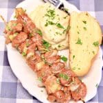 Pork Kabobs on a plate with mashed potatoes and garlic bread.