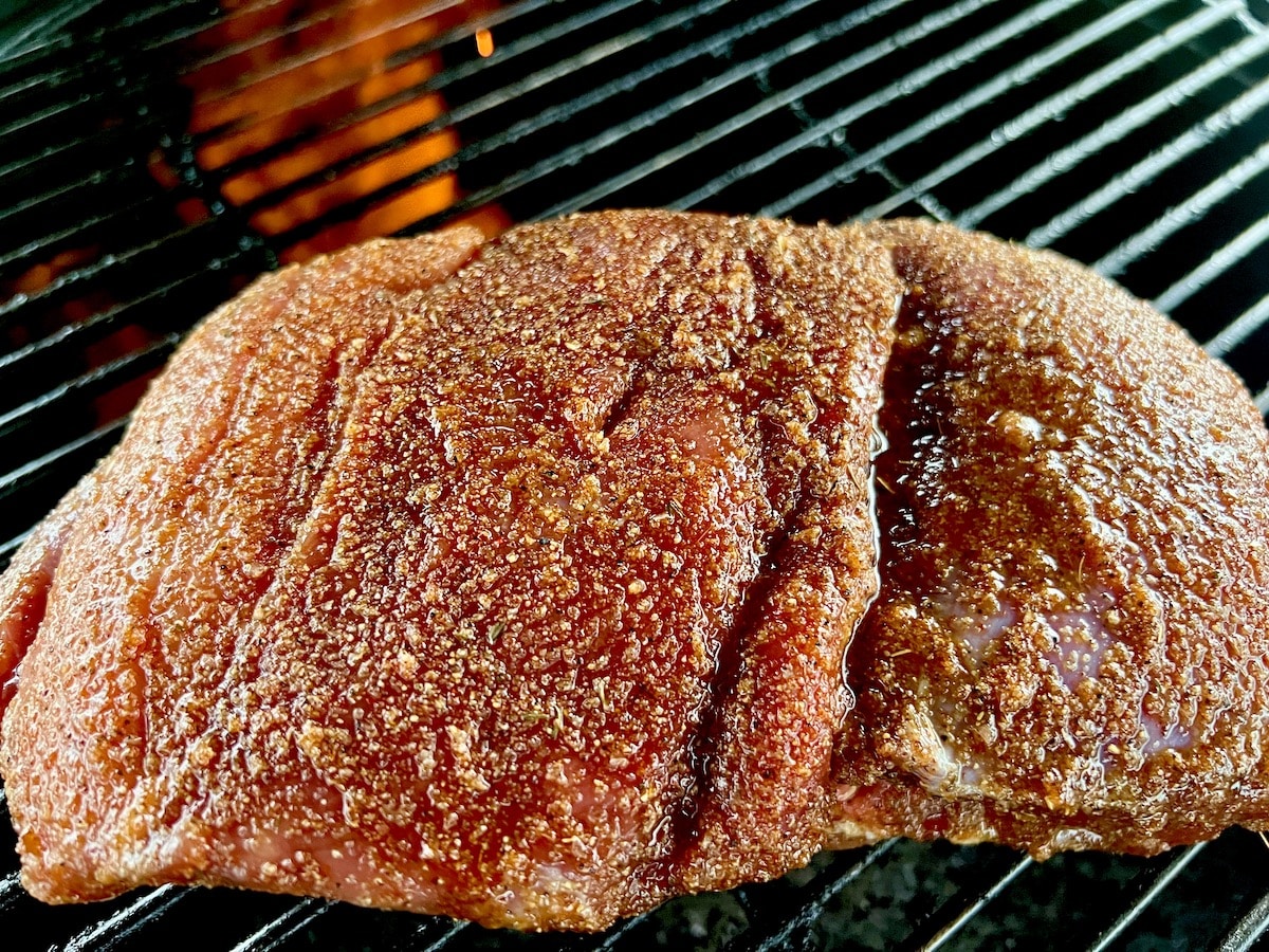Raw venison roast on a grill.