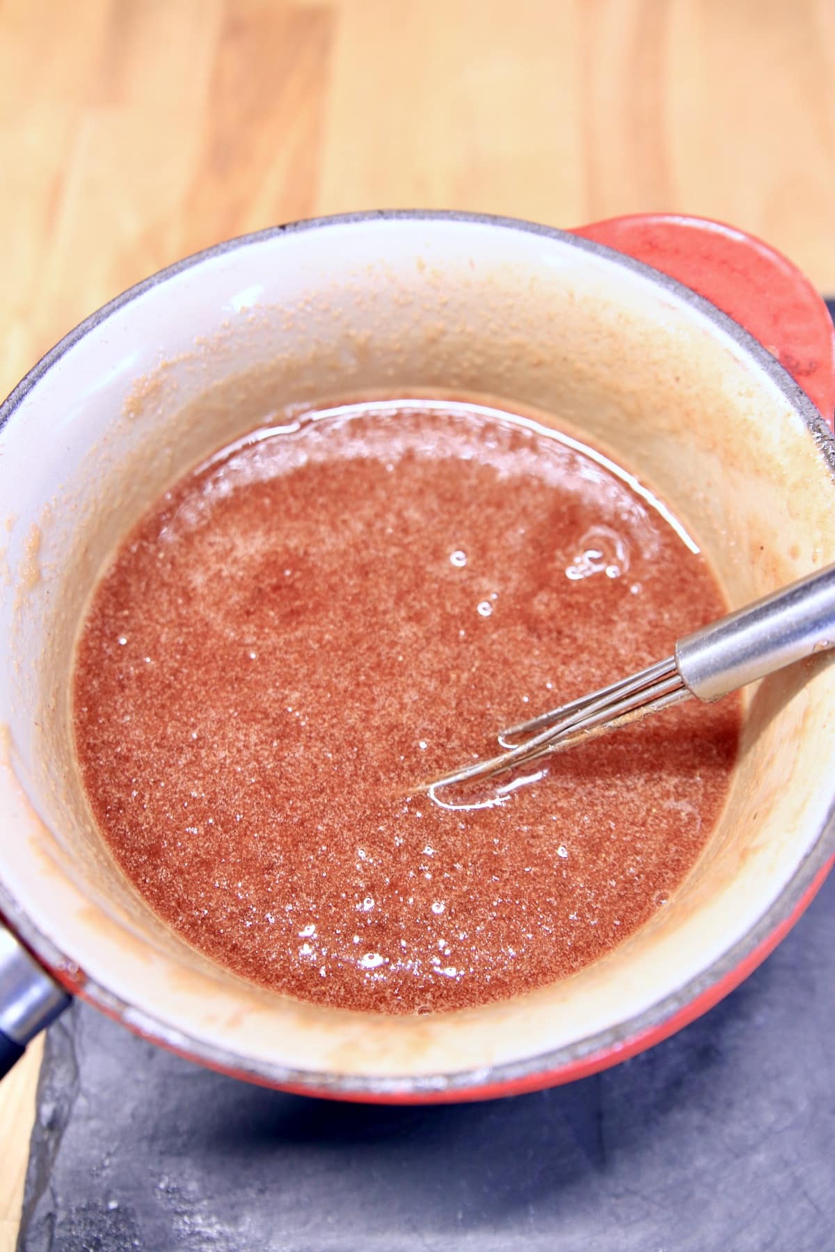 Plum sauce in a pan with whisk.