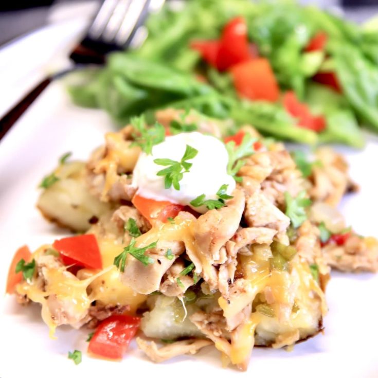 Chicken stuffed baked potato with cheese, sour cream and tomatoes.