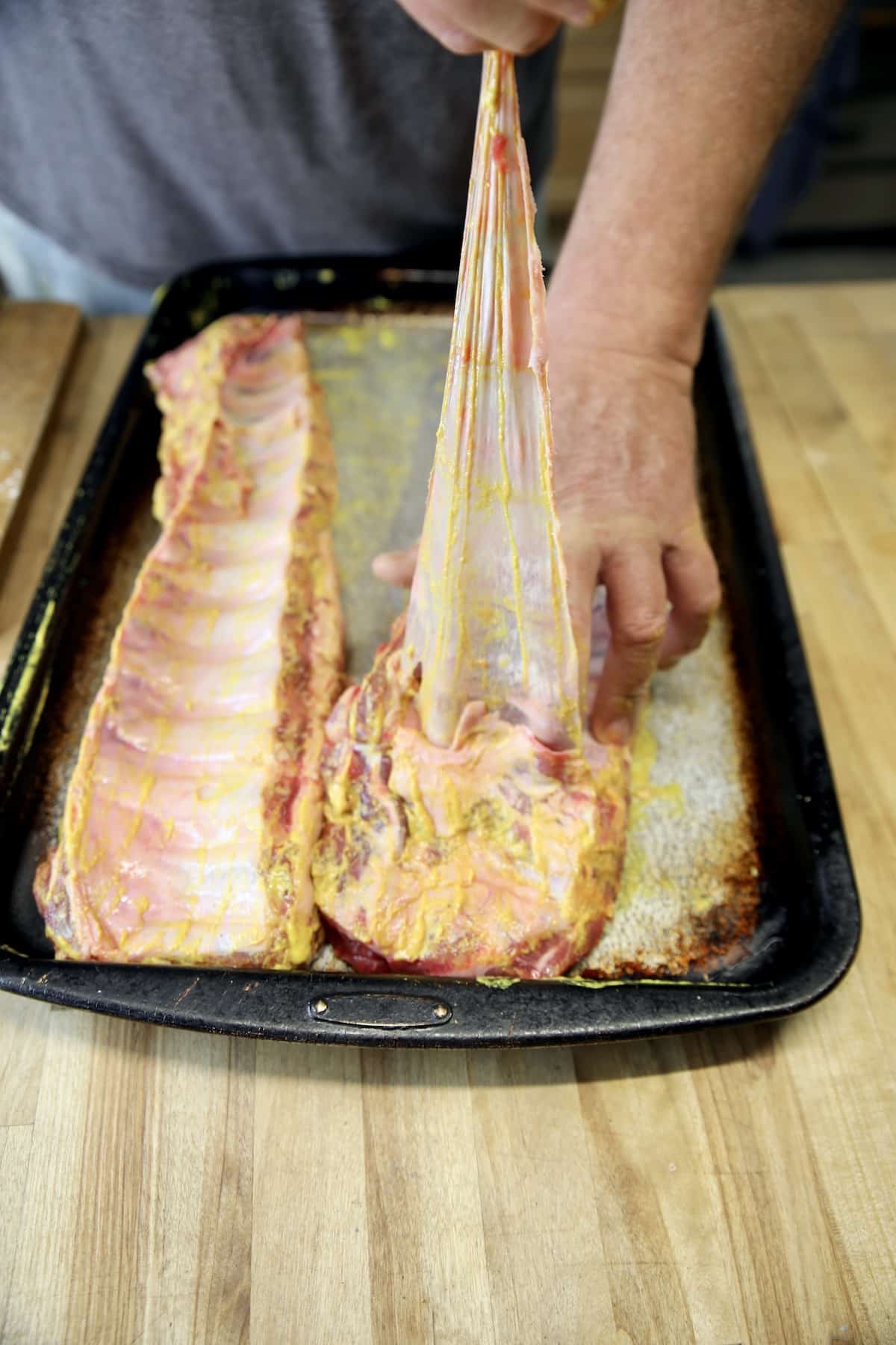Pulling membrane from baby back ribs.
