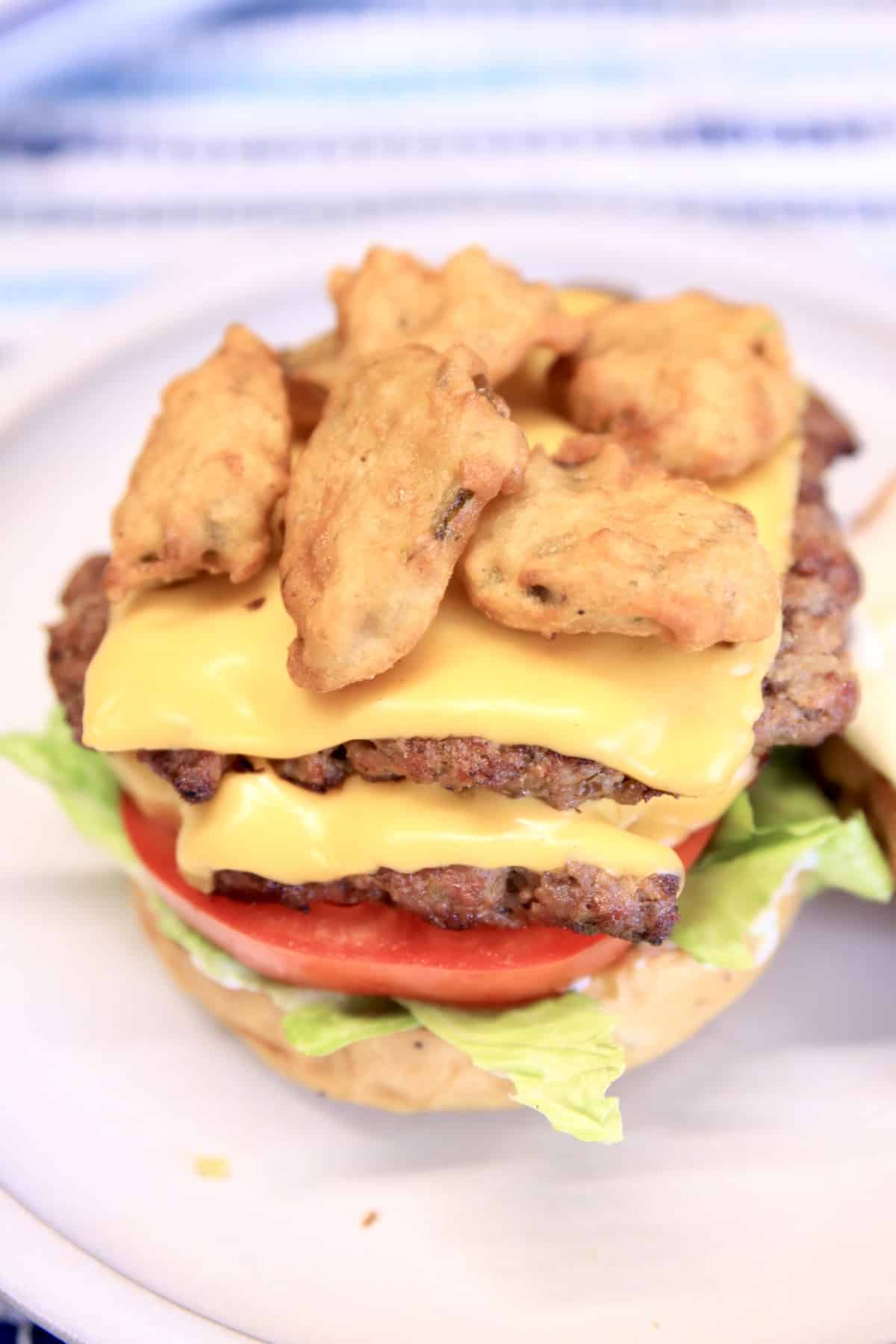 Double cheeseburger with fried pickles (top bun missing).