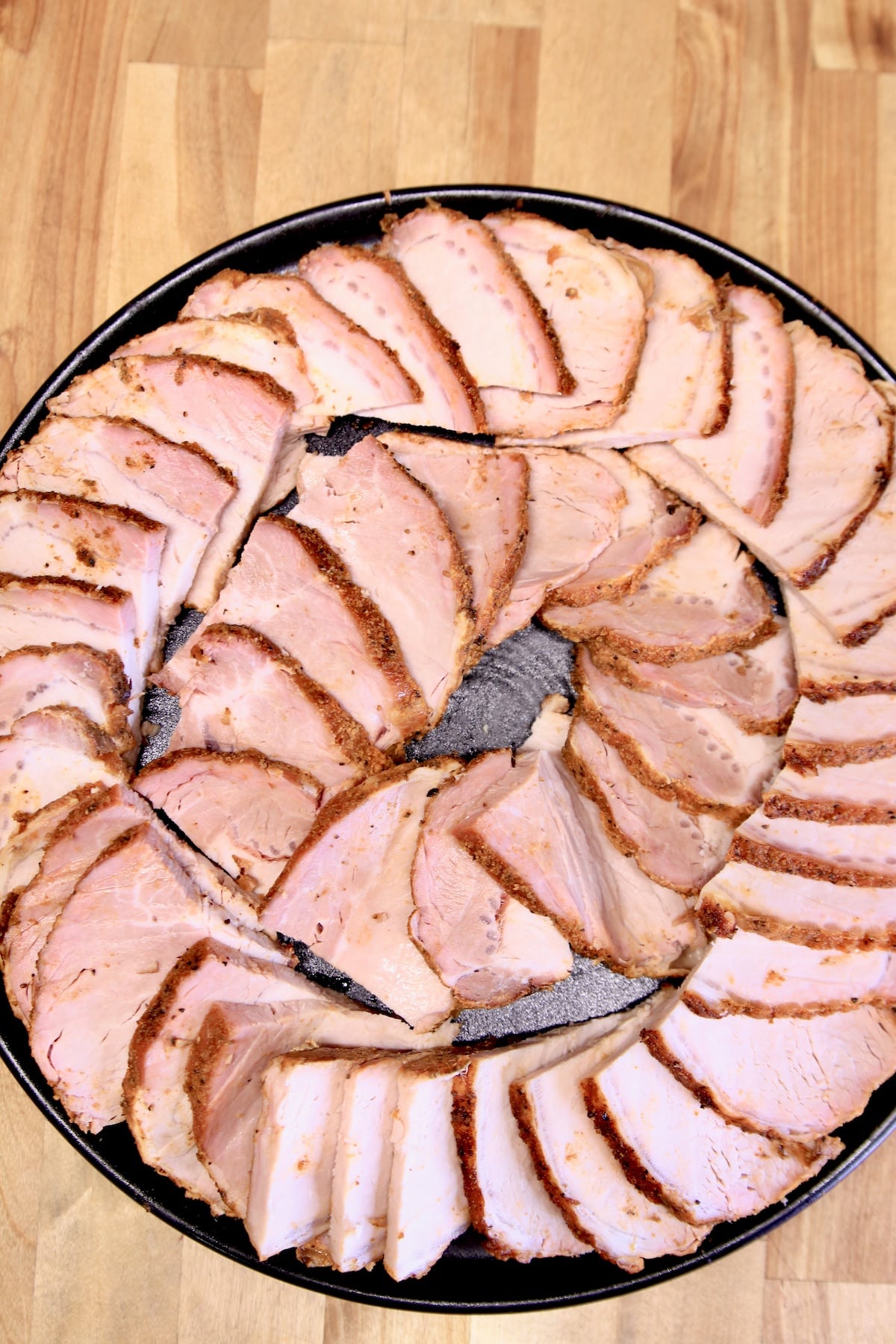 Sliced pork on a round platter.