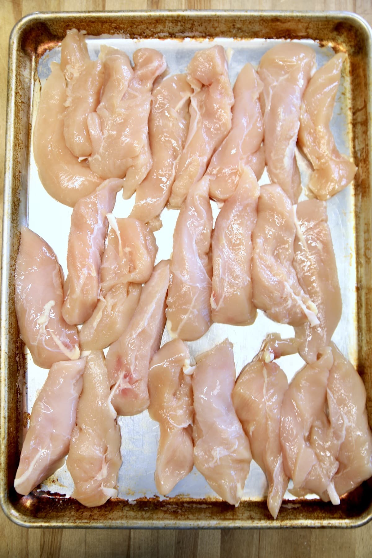 Chicken tenders on a sheet pan.