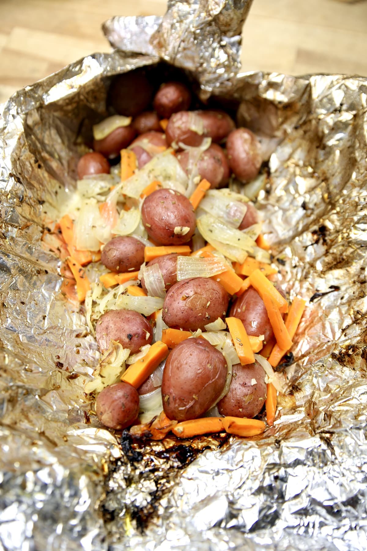 Foil packet of potatoes, carrots and onions.