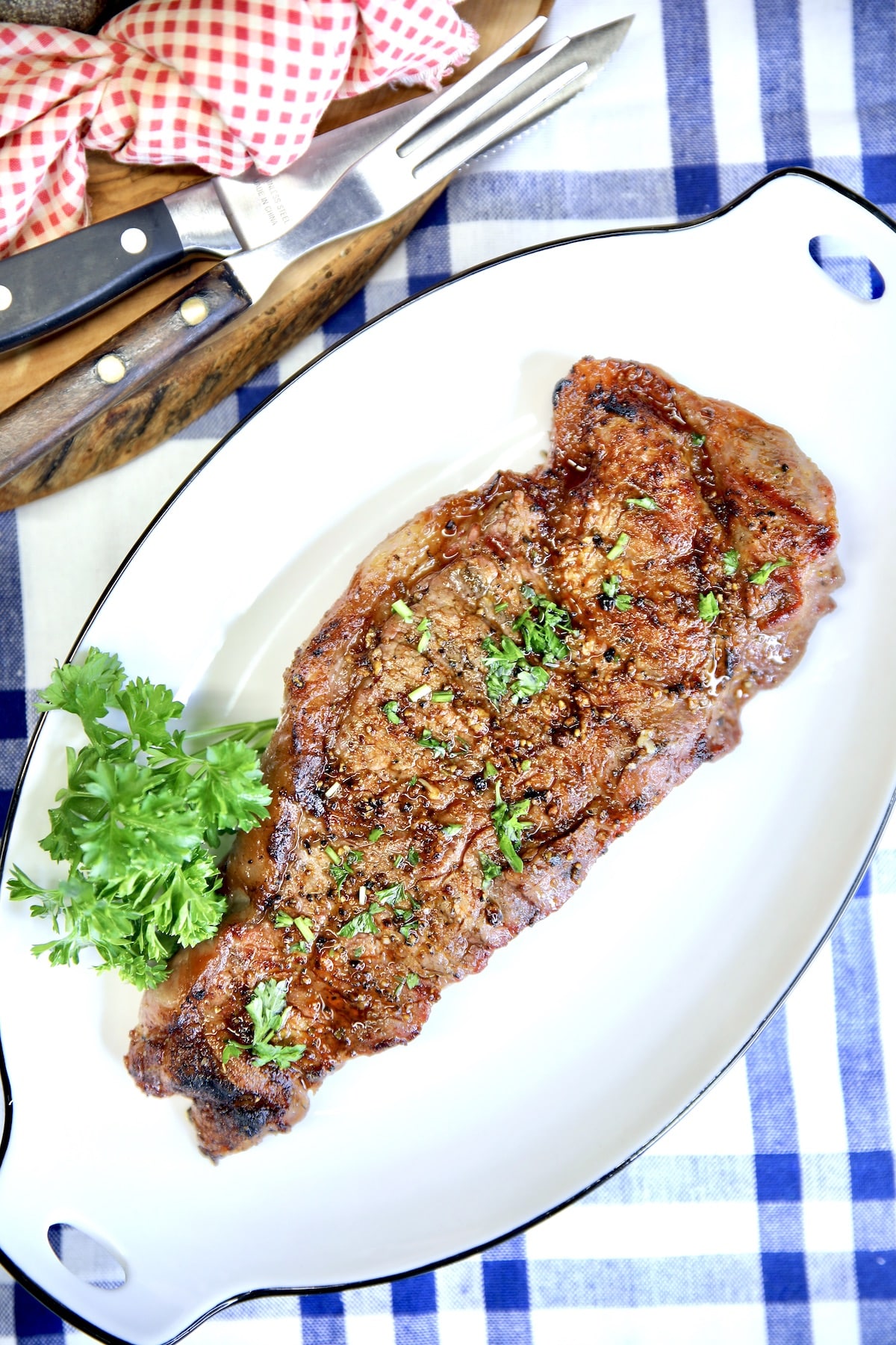 Platter with grilled strip steak, parsley.