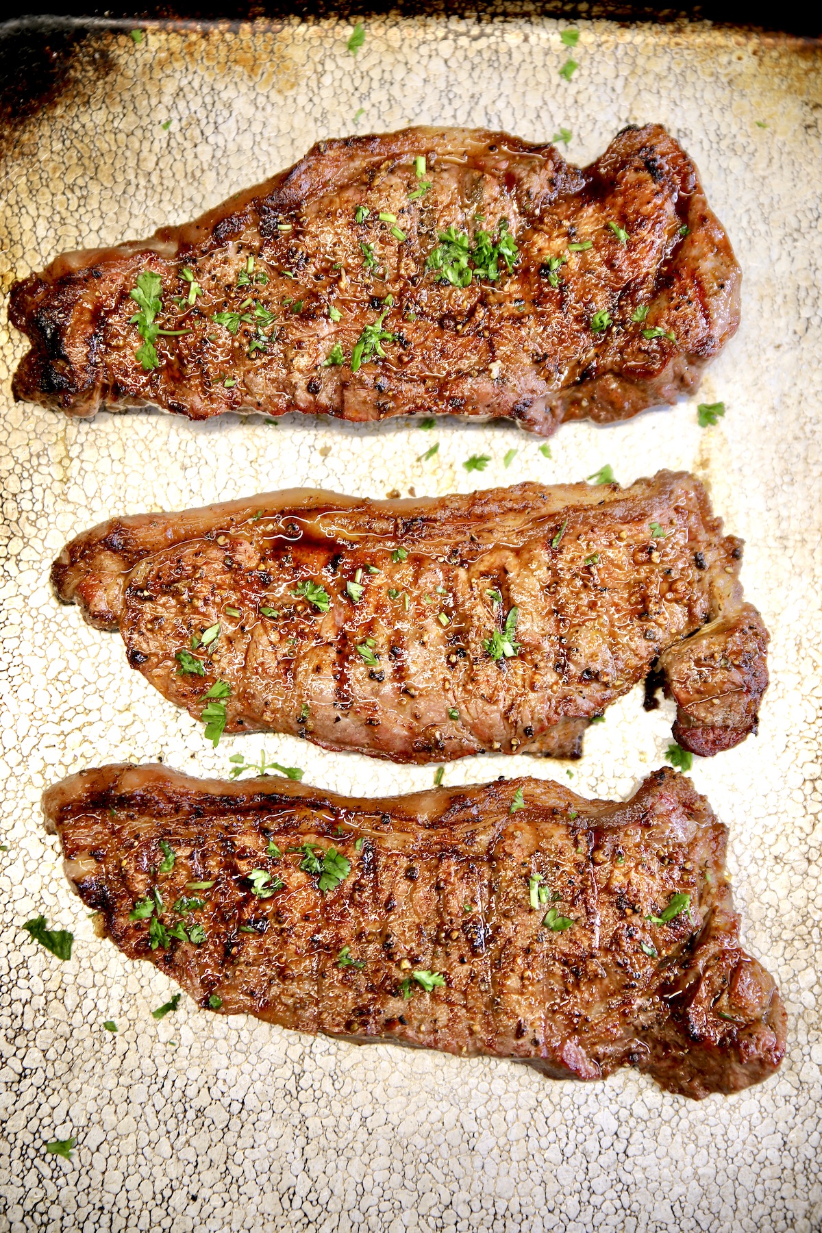 Sheet pan with grill strip steaks.