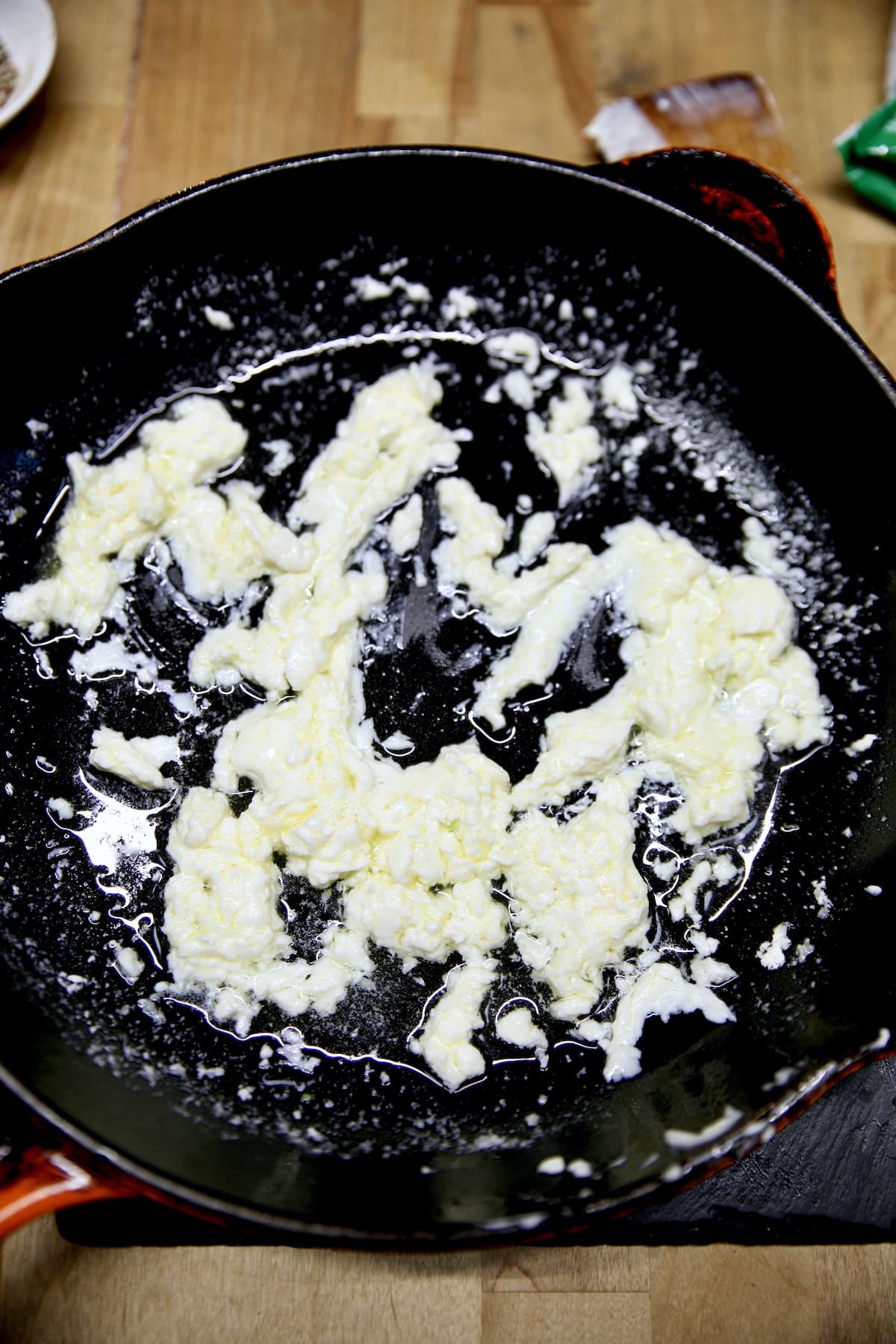 Skillet with melted cream cheese, butter and garlic.