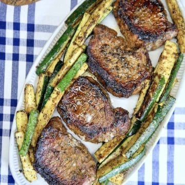 Platter of grilled pork chops and zucchini.