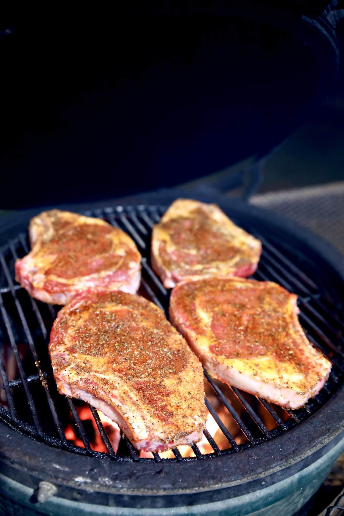 4 ribeye steaks on a grill.