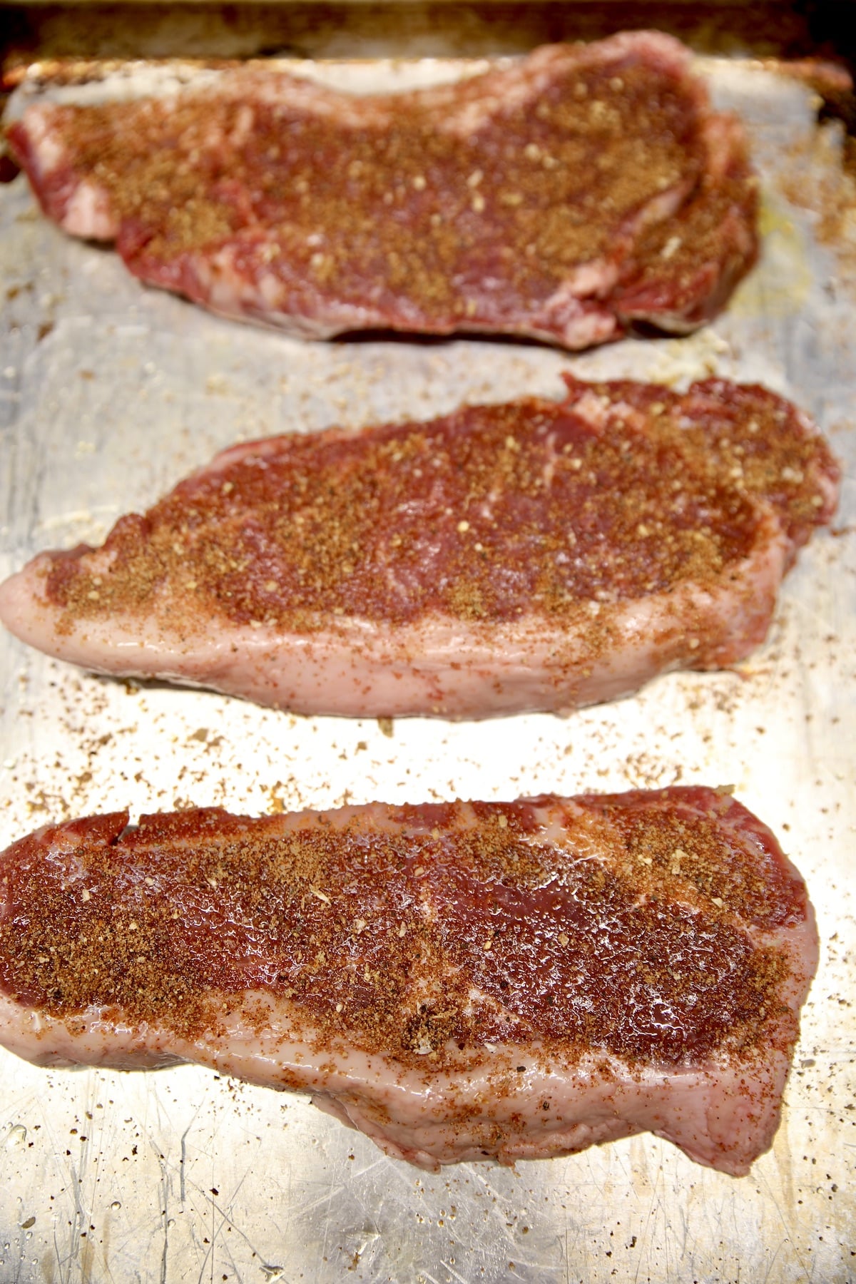 3 NY Strip steaks with dry rub seaoning.