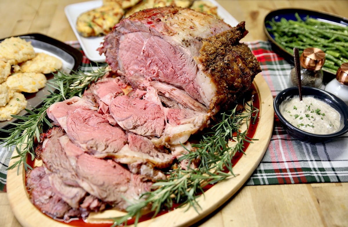 Prime rib roast, partially sliced on a cutting board.