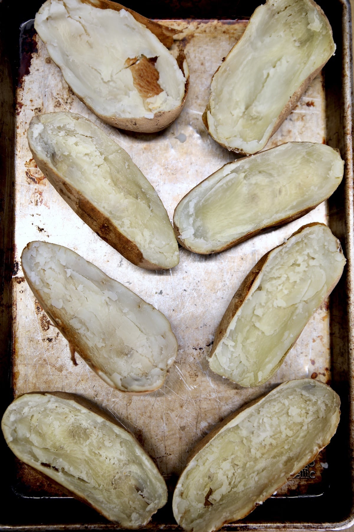 Potato skins halves on a sheet pan.